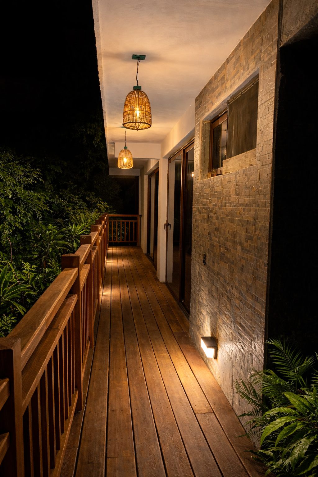 The timber corridor at night, lit by woven pendant lamps.